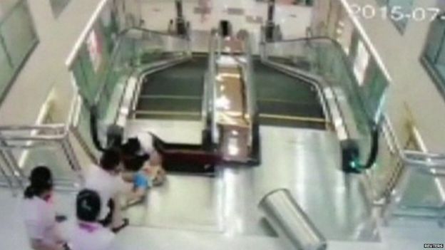 Cứu con, mẹ bị thang cuốn nuốt chửng ảnh 1