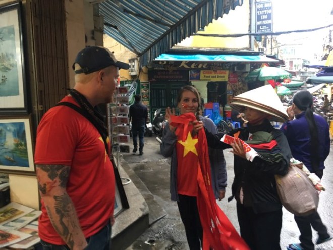 Người nước ngoài mua băng rôn, áo ở phố Tạ Hiện (Hà Nội).
