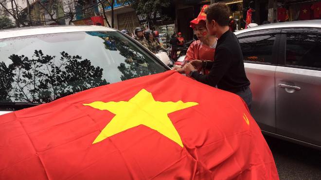 Anh Lê Long (Giảng Võ) mua cờ  trang trí chiếc ô tô của mình để cổ vũ cho đội tuyển.