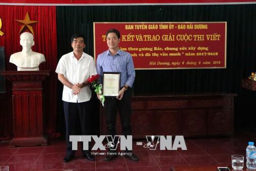 Ông Nguyễn Hồng Sơn (bên trái), Trưởng Ban Tuyên giáo Tỉnh ủy, Trưởng ban Tổ chức cuộc thi trao giải Nhất cho tác giả đoạt giải.