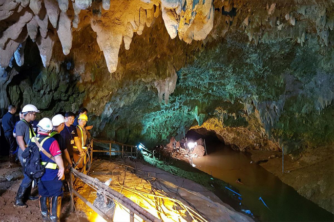 Lực lượng cứu hộ và giới chức Thái Lan quan sát khu vực hang Tham Luang đang được bơm nước ra ngoài ngày 29/6/ 2018. Ảnh: EPA-EFE